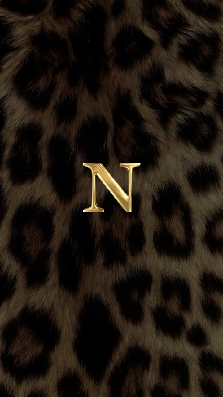 A metallic gold capital N centered on a dark brown and black leopard print background.