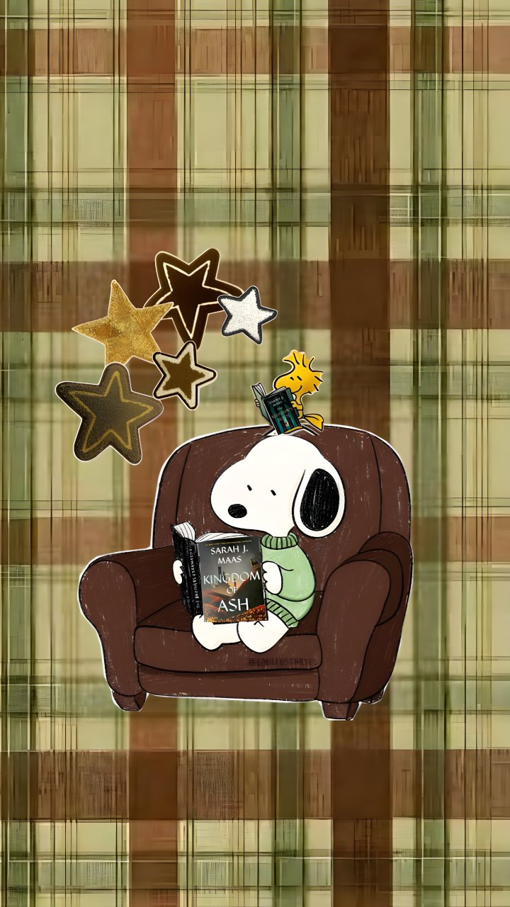 Snoopy sits in a brown armchair reading Kingdom of Ash, with a small yellow character and star decorations against a warm plaid background.
