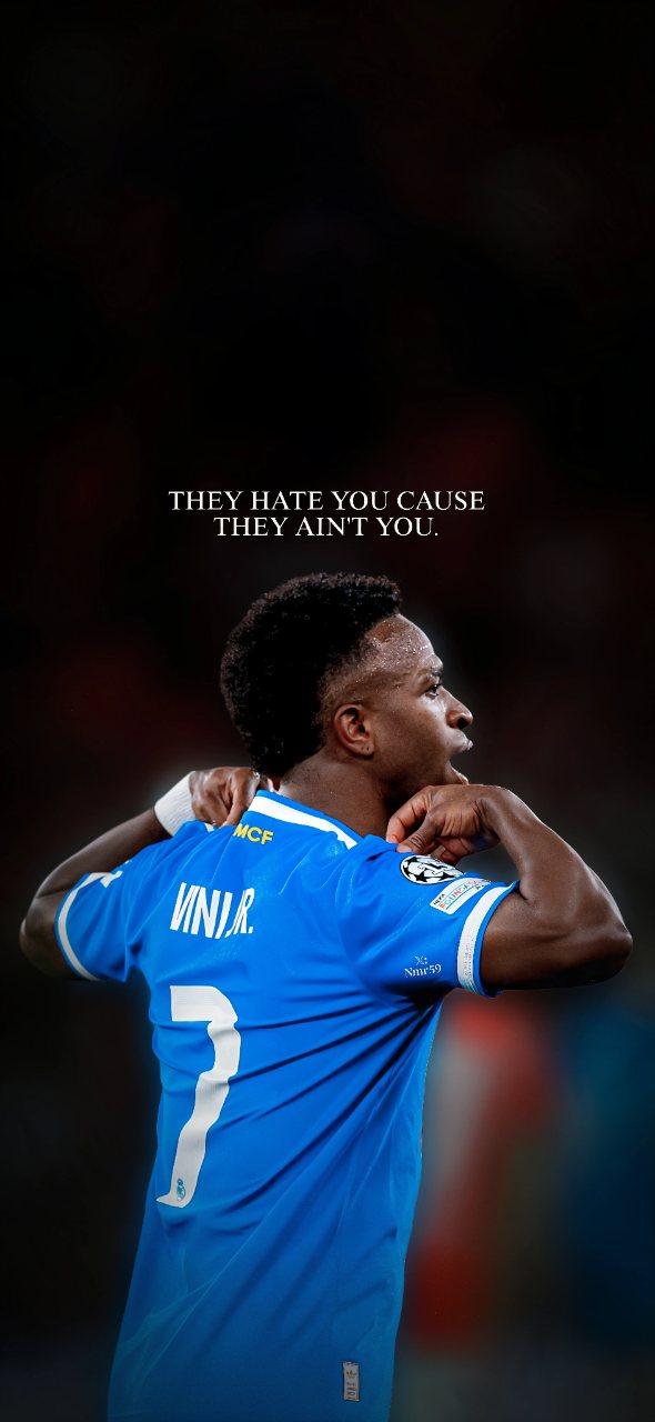 Vinícius Jr in a blue number 7 football jersey with his arms raised beneath the quote “They hate you cause they ain’t you.”